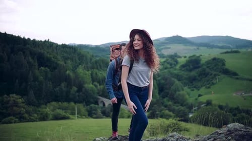 Couple Hiking Together on a Beautiful Green Hill