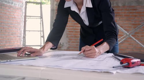 Business Person Working on Blueprint in Office