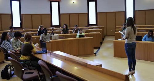Teacher guiding diverse students through project in classroom at university
