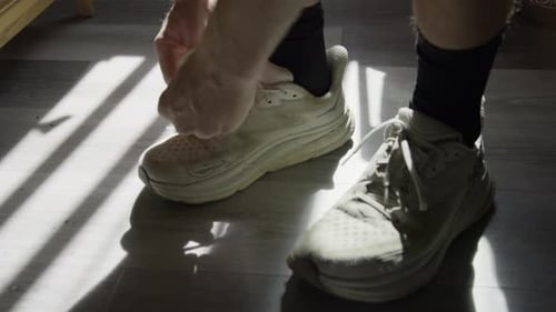 Man Tying Shoelaces Before Run in Sunlight