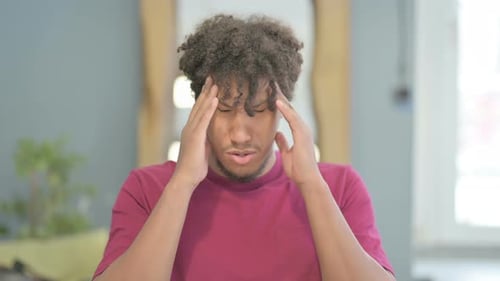 Man with Curly Hair Rubs Temples