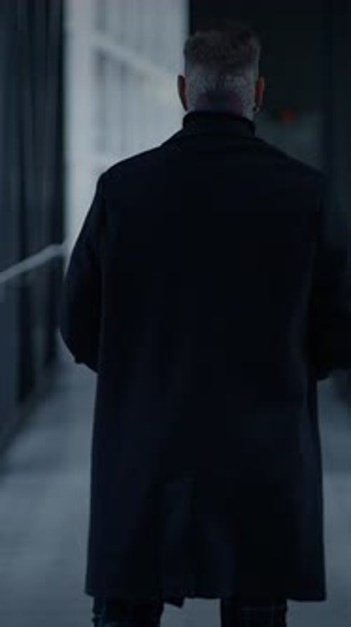 Man Walking Down Dark Urban Hallway