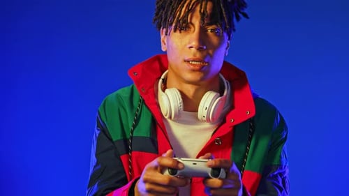 Young Adult Playing Video Game, Blue Background