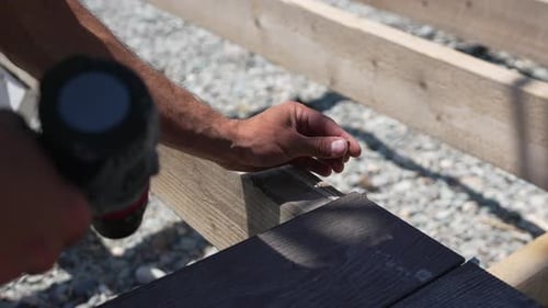 Building Decking Screw Hand Fastening Dark Composite Board Onto Wooden Frame Outdoor Project