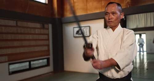 Aikido, sword and master fight with a katana in traditional Japanese class, gym or competition