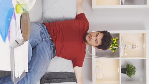 Young Man Lying on Sofa in Living Room