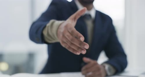 Imágenes de vídeo en 4K de un empresario extendiendo su brazo para darle la mano en una oficina moderna