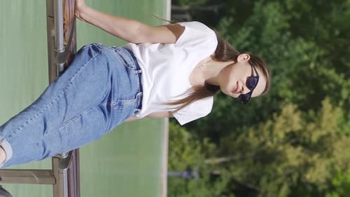 Vertical Video of Happy woman sings to herself in the park.