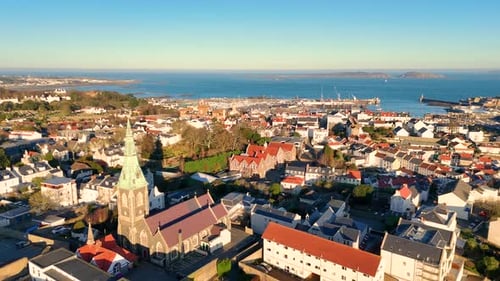 High forwards drone footage of the roof tops of St Peter Port Guernsey in the golden hour with views