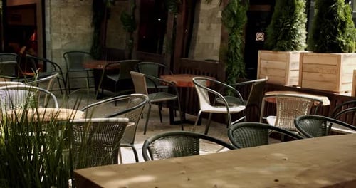 Wooden Tables with Black Modern Charis in Cafe on the Street