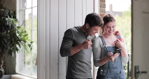 Couple Looking at Mobile Phone in Domestic Setting