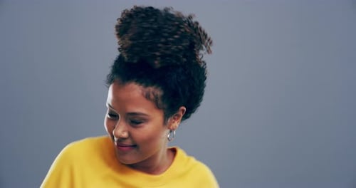 Woman Dancing and Smiling Against Gray Background