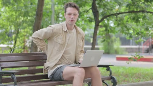 Young Adult Working on Laptop, Experiences Back Pain