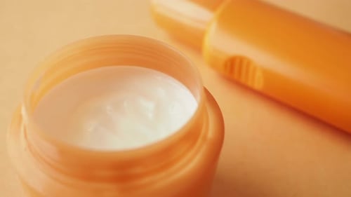 Close Up of Sunscreen Cream Ion Orange Color Background