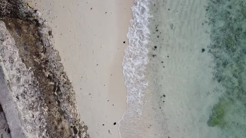 Birds eye view of beach shore waves crashing drone shot