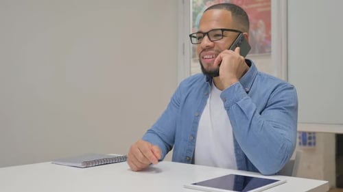 African Businessman Talking on phone in Office