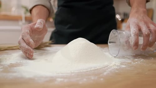Hands Pouring Flour in a Kitchen