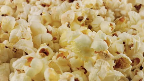 Rotating popcorn grains. Popcorn background. Macro and close-up.