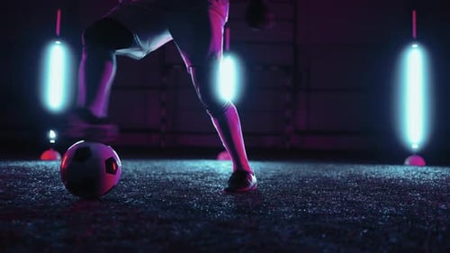 Training of Soccer Player at Night Closeup View of Talented Footballer Kicking Ball in Dark Studio