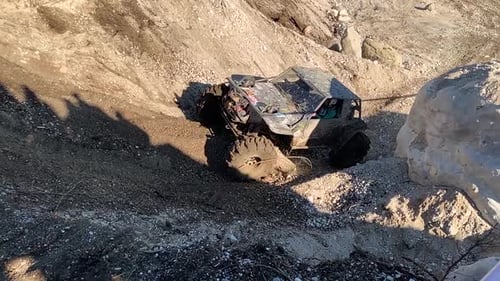 Extreme offroad car with huge suspensions at the competition. Offroad racing car racing uphill in th