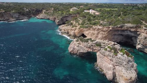 Es Pontas Natural arch, and eroded shoreline, Mallorca rocky coastline, drone view