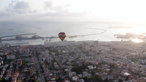Hot air balloon above Haifa bay and Downtown area at sunrise, Aerial view
