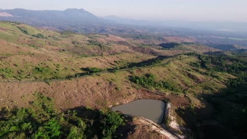 Cinematic Drone Flight Tilting Down to Road in Hilly Landscape