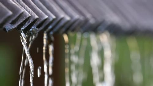 Water run drain pipe close up. Heavy rain season pour. Drizzle flow slope roof.