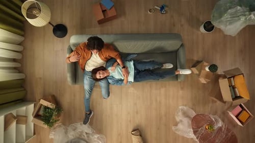 Top View of Living Room Man Sitting on the Couch in New Apartment Woman Laying on His Thighs Happy