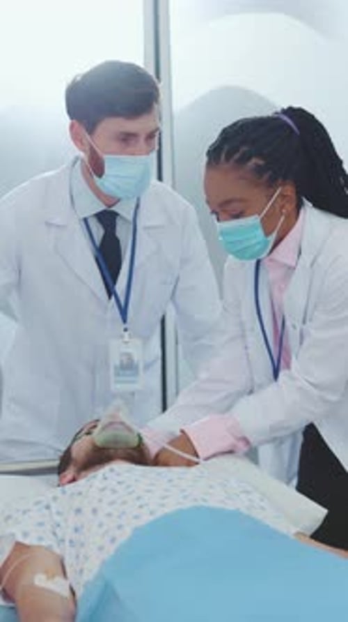 Doctors Moving Patient on Gurney Through Hospital