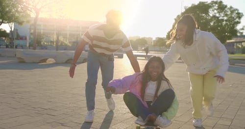 Multiethnic Group of Young Happy Friends Having Fun and Skating Down the Street in Slow Motion