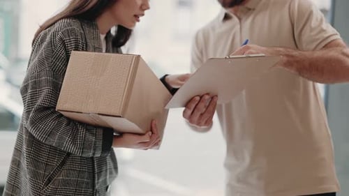 Woman Signing For Package From Delivery Person