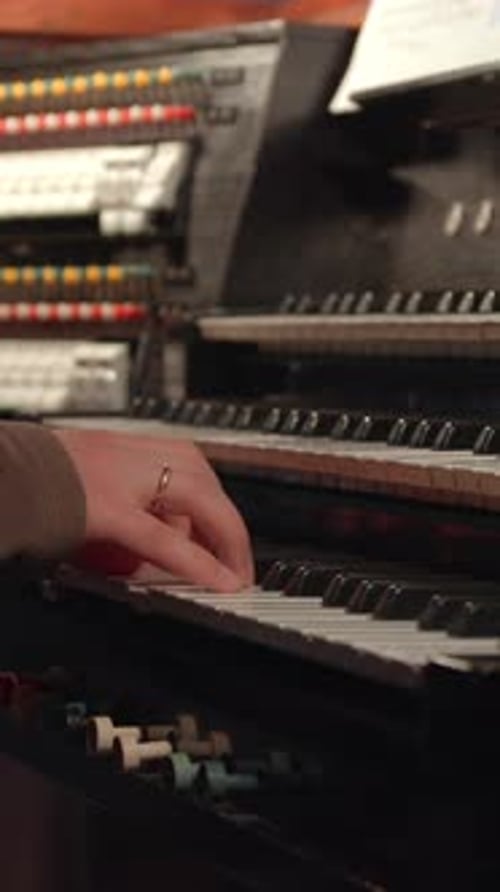 Closeup Of Musician Practicing Hymn Arrangements And Adjusting Instrument Settings In Quiet Chapel