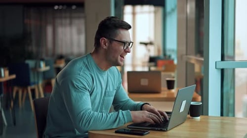 Man Working on Laptop in Modern Workspace