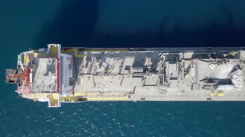 Top down aerial footage of a large Cement carrier ship at sea