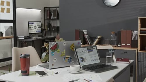 Large Desk with Two Laptops, Notebook, Documents, Coffee Cup, Phone, Travel Mug