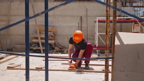 Construction Worker Working on Wood at Building Site