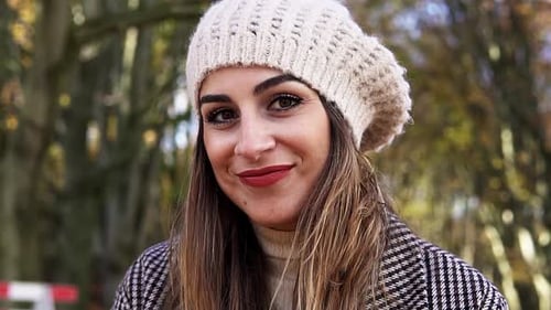 Smiling Woman in Beanie Standing Outside