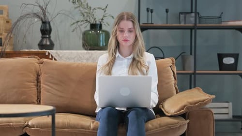 Woman Uses Laptop While Sitting on Couch