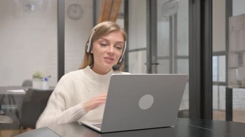 Woman with Headset on Video Call in Office