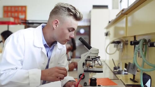 High School Student with Microscope in Laboratory
