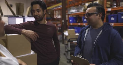 Manager and Workers Talking Meeting in Distribution Warehouse 10 Seconds or Greater