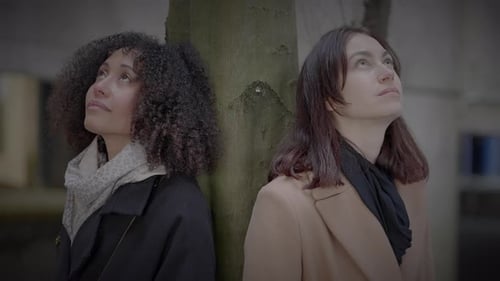 Lifestyle Portrait of Two Young Women Watching Tower Building Together