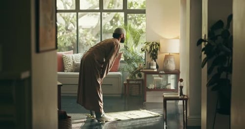 Man Bowing in Prayer in a Sunny Home