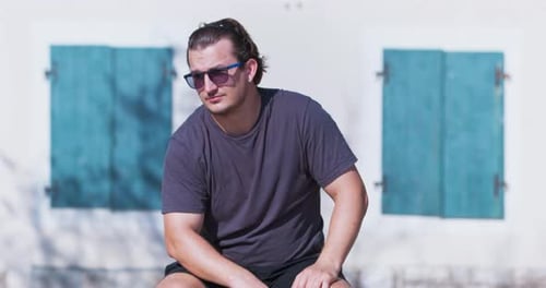 Young Adult Sitting Outside, Relaxing on Sunny Day