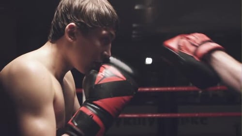 Boxeadores latinos entrenando en un saco de boxeo en un gimnasio