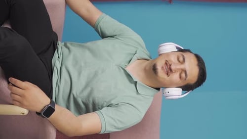 Man Listening to Music Relaxing in Armchair Indoors
