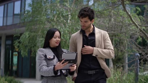 Business Professionals Discussing Ideas While Walking Outside