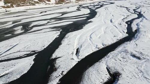Malerischer Fluss in verschneiter isländischer Landschaft, Luftaufnahme von oben