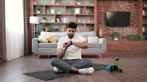 Young Male Using Fitness Tracker for Home Training